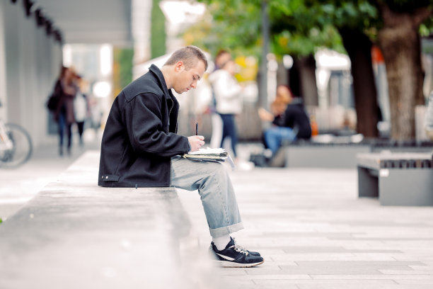 年轻的涂鸦艺术家在城市街道上素描图片下载