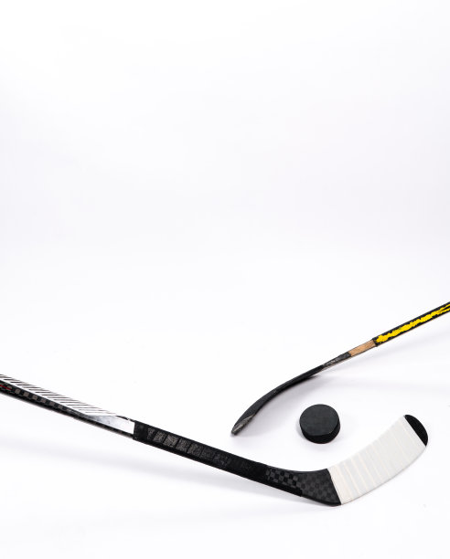 冰球和曲棍球棒在孤立的白色背景，复制空间。图片下载