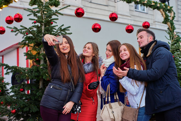 五个年轻人在圣诞市场拍照片图片下载