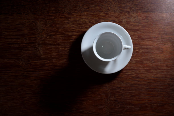 咖啡杯和盘子放在木桌上。图片下载