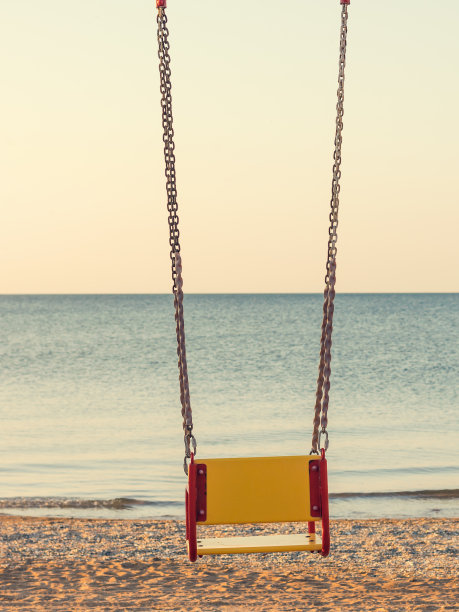 空空的秋千对着黄昏的大海。图片下载