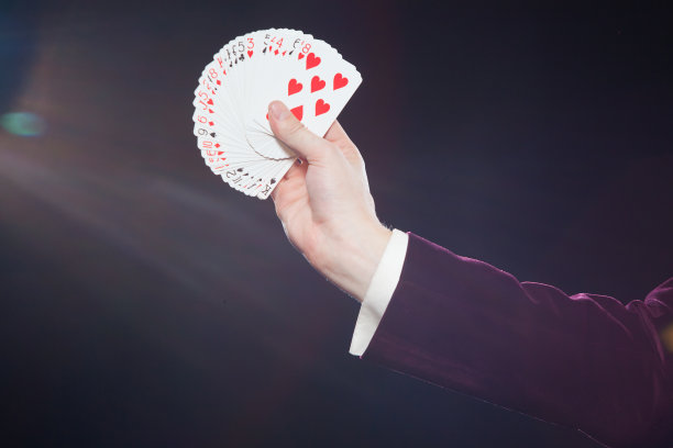 手与卡片特写。魔术师的腹部显示扇形的卡片在黑色的背景。魔术师，变戏法的人，有趣的人，黑魔法，幻觉图片下载