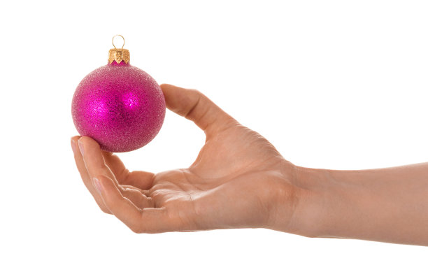 明亮的球玩具装饰圣诞树，在女性的手，孤立的白色图片下载