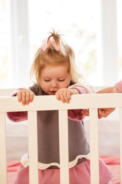 婴儿站在婴儿床上图片下载