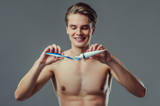 灰色背景上的英俊男子。图片下载