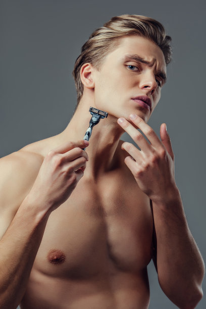 灰色背景上的英俊男子。图片下载