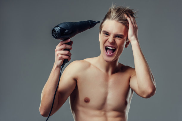 灰色背景上的英俊男子。图片下载