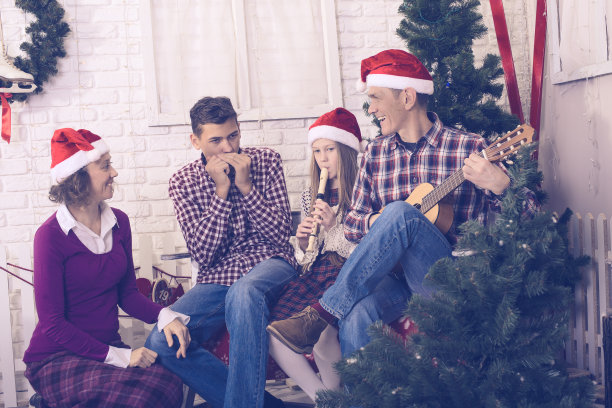 幸福的一家人在圣诞树前唱歌图片下载