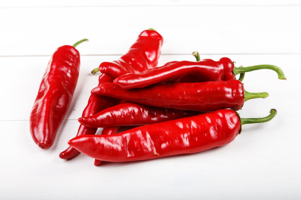 木桌上放着一堆红辣椒。图片下载