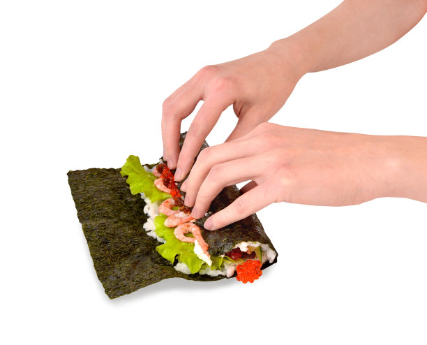 女孩在做寿司。烹饪食物。日本的食物。图片下载