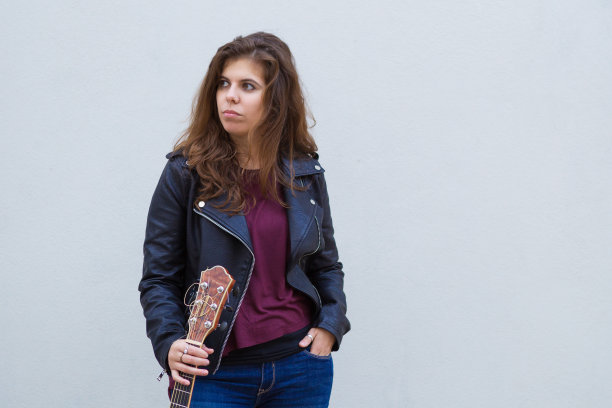 沉思年轻迷人的女孩拿着吉他图片下载