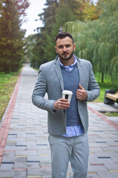 年轻性感的家伙漫步在秋天，夏天的公园。人在喝咖啡，人在喝茶。欧洲的乡村。设计素材照片图片下载