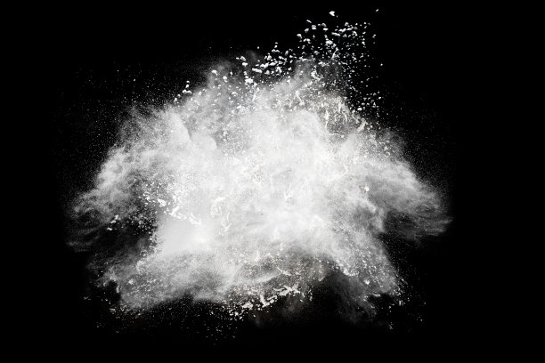 黑色背景上的白色尘埃的定格爆炸。把滑石粉从手上扔出去。停止白色粉末在黑色背景上的移动。图片下载