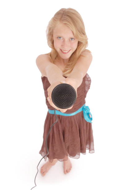 一个手持麦克风的少女站在前面图片下载