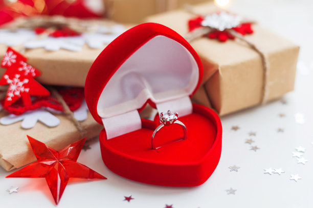 圣诞节和新年背景与订婚戒指和礼物，装饰圣诞树。假日背景与星星、五彩纸屑和灯泡。文本。图片下载