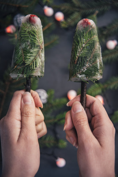 冰淇淋从常青树的树枝上落在女孩的手中图片下载