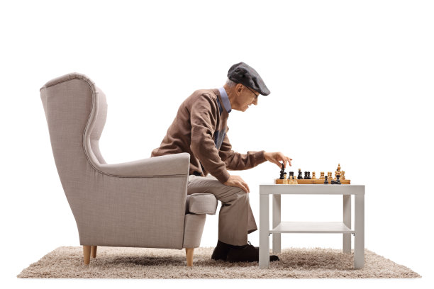一位老人坐在扶手椅上和自己下棋图片下载