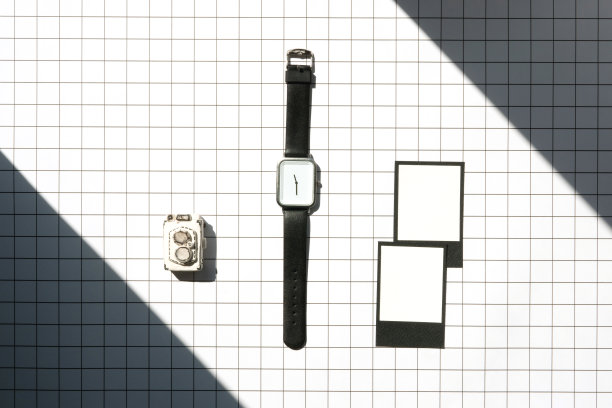 简单的手表与小模型相机与白纸上的几何背景与阴影的光图片下载