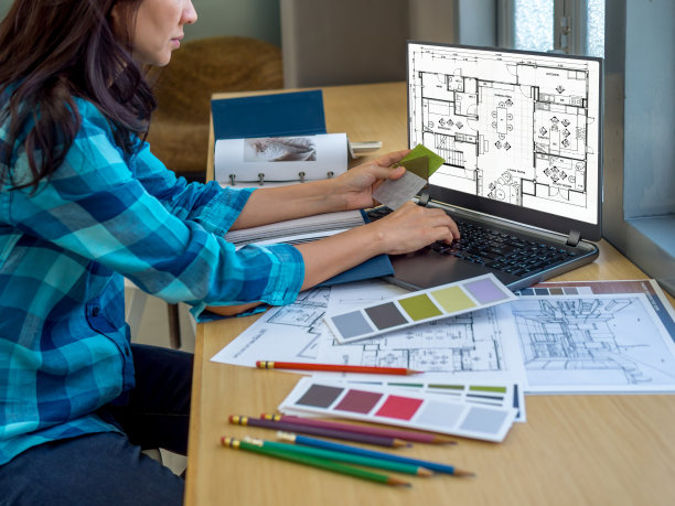 建筑师(室内设计师)在办公室使用图纸，材料样品和笔记本电脑工作图片下载