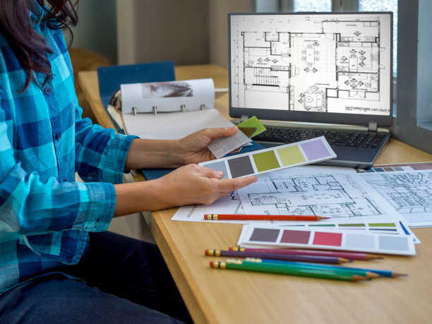 建筑师(室内设计师)在办公室使用图纸，材料样品和笔记本电脑工作图片下载