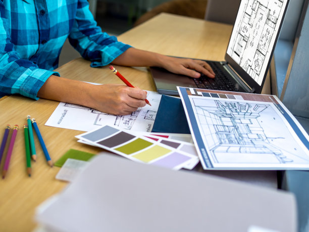 建筑师(室内设计师)在办公室使用图纸，材料样品和笔记本电脑工作图片下载