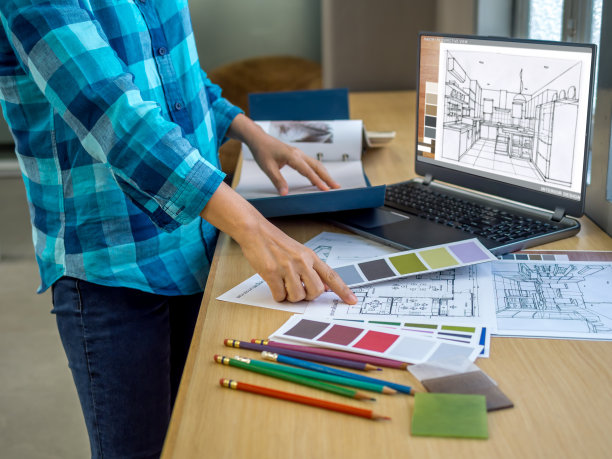 建筑师(室内设计师)在办公室使用图纸，材料样品和笔记本电脑工作图片下载