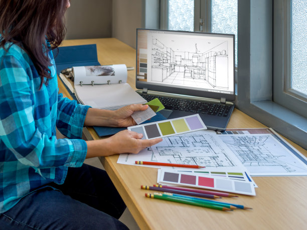建筑师(室内设计师)在办公室使用图纸，材料样品和笔记本电脑工作图片下载