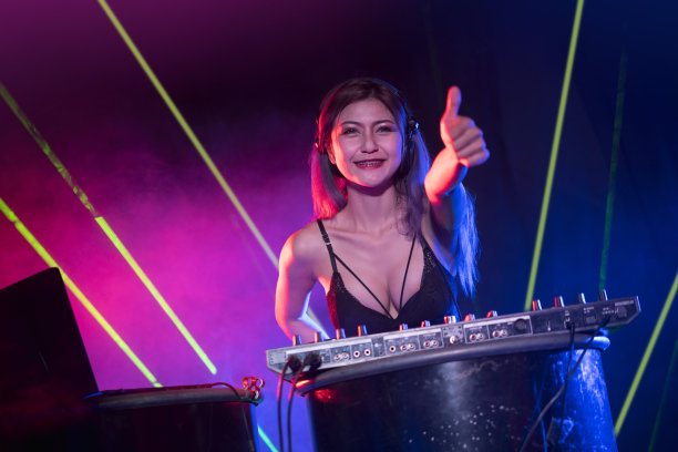 性感的DJ正在播放音乐，在夜总会的混音机上混音。她的手指向上，喜欢音乐。图片下载