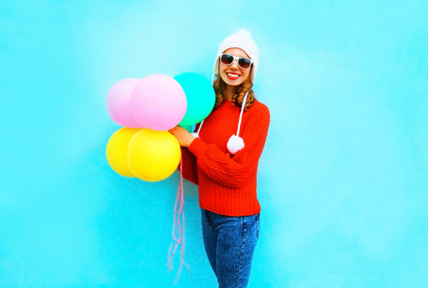 可爱的年轻微笑的女人，一个气球在一个彩色的背景图片下载