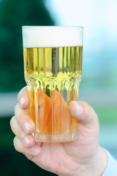 男人的手拿着一杯淡啤酒。图片下载
