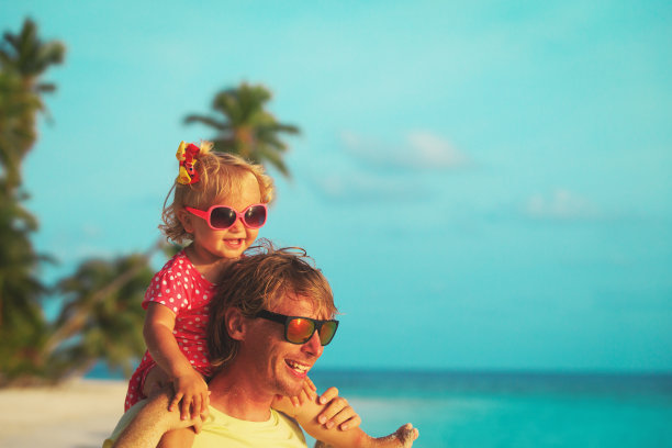 快乐的父亲和小女儿在热带海滩上图片下载