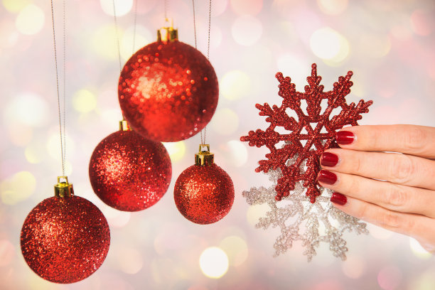 女性的手用专业的节日红色和银色美甲图片下载