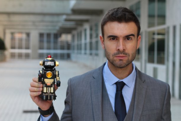 一个商人在办公室里拿着一个机器人图片下载