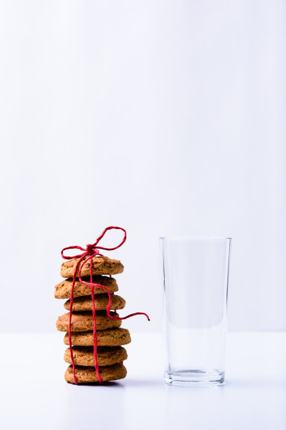 一堆圣诞饼干和一个空的水杯。近距离图片下载