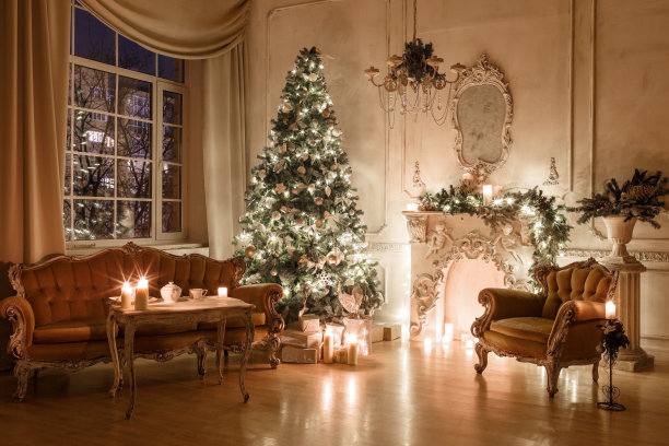烛光下的圣诞夜晚。经典的公寓，白色壁炉，装饰的树，沙发，大窗户和枝形吊灯。图片下载