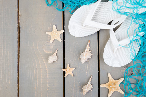 贝壳和白色人字拖灰色木制背景。平的。图片下载