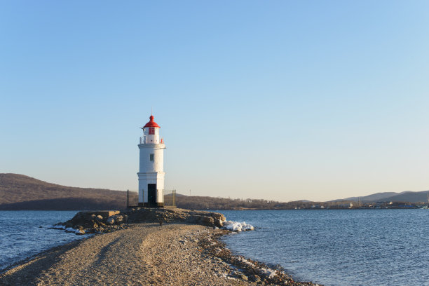 日落时海岸上的灯塔。图片下载