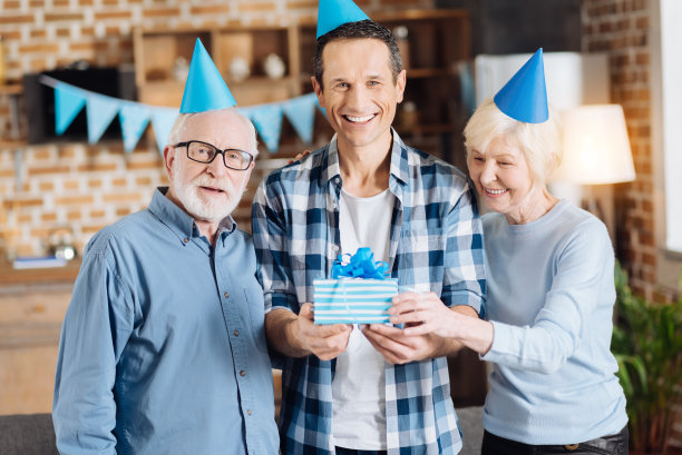 欢乐的家庭与一个礼物盒在生日聚会摆姿势图片下载