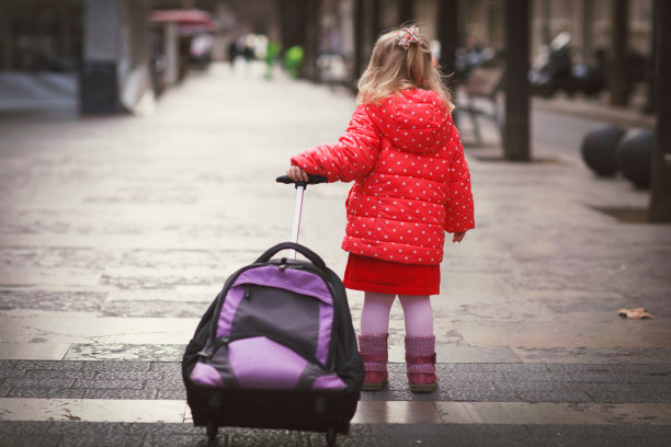 小女孩带着行李箱在城里旅行图片下载
