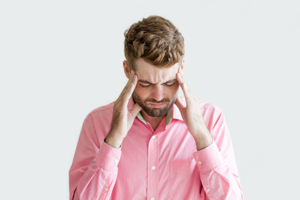 紧张的年轻英俊男子触摸太阳穴图片下载
