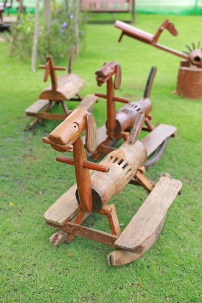 木制摇椅玩具像狗在绿色的草地上的花园。图片下载