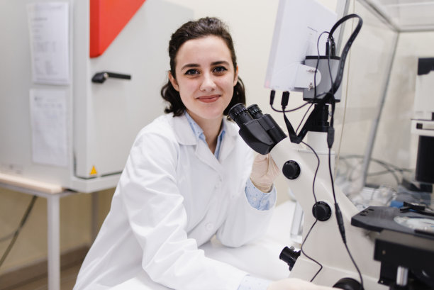 在遗传学实验室里，年轻的大学生用可爱的表情看着照相机。图片下载