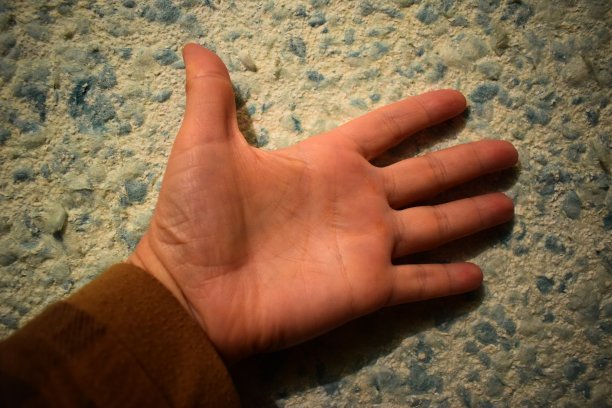 用你的左手在液体墙纸上刷墙。图片下载