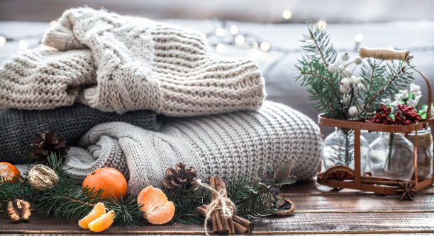 圣诞静物生活的圣诞树，装饰品和节日花环的背景针织衣服图片下载