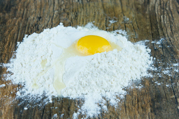 碎鸡蛋堆在一堆面粉上，准备拌成面包图片下载