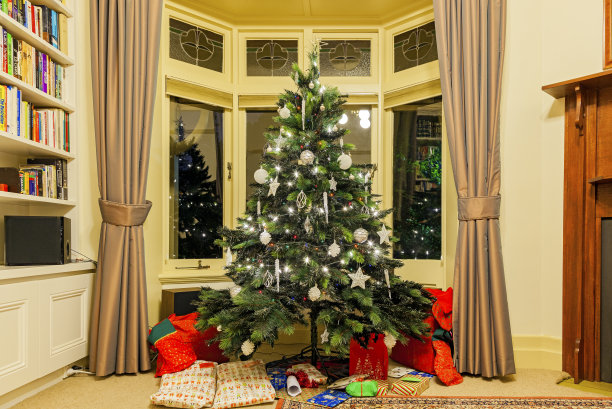 圣诞家居装饰:圣诞树与礼物点燃在晚上图片下载