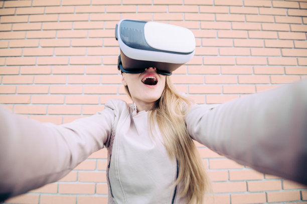 年轻女子戴着虚拟现实模拟器眼镜图片下载