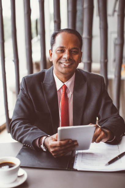 微笑的印度商人在咖啡馆工作图片下载