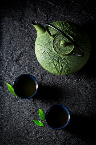 特写的绿茶与茶壶上的黑岩图片下载
