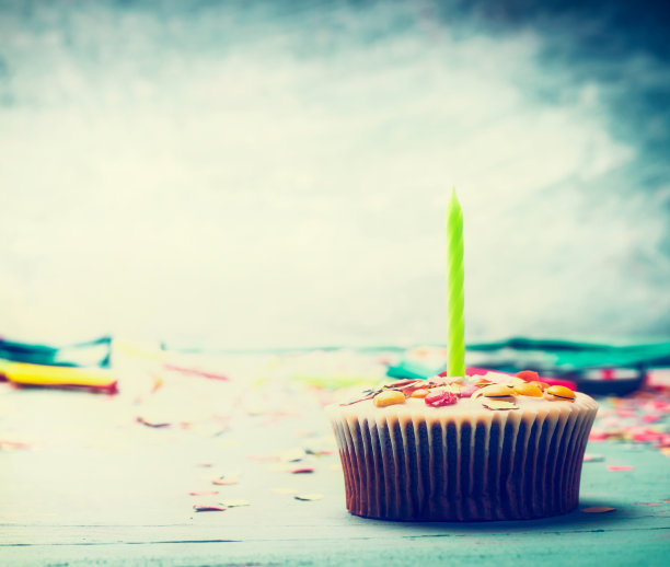 生日蛋糕，桌上有蜡烛，背景为蓝绿色图片下载